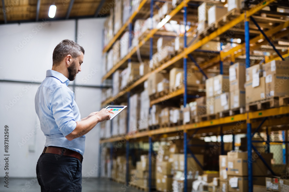 Man warehouse worker with a tablet.